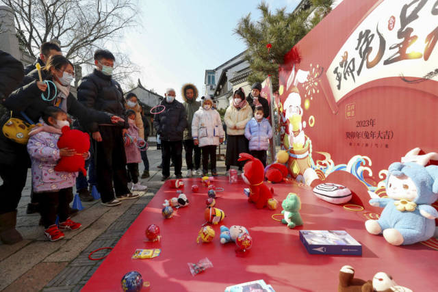 1月24日,游客在苏州黎里古镇玩套圈游戏。新华社记者 方喆 摄 1月24日,游客在苏州黎里古镇玩套圈游戏。新华社记者 方喆 摄