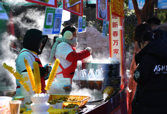 1月25日,游客在济南千佛山新春游园会上选购美食。新华社记者 朱峥 摄 1月25日,游客在济南千佛山新春游园会上选购美食。新华社记者 朱峥 摄