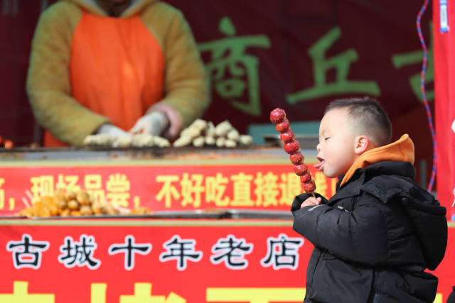 1月25日,一名小朋友在河南省商丘市古城新年大集上品尝糖葫芦。新华社发(李恒 摄) 1月25日,一名小朋友在河南省商丘市古城新年大集上品尝糖葫芦。新华社发(李恒 摄)