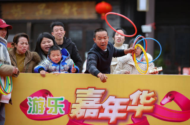 1月25日,游客在贵州省黔东南苗族侗族自治州丹寨县万达小镇庙会上玩套圈游戏。新华社发(黄晓海 摄) 1月25日,游客在贵州省黔东南苗族侗族自治州丹寨县万达小镇庙会上玩套圈游戏。新华社发(黄晓海 摄)