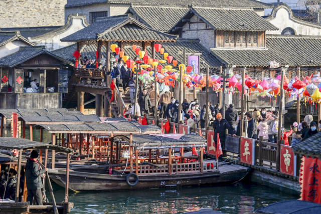 1月25日,游客在浙江省桐乡市乌镇景区逛“水上年市”。新华社记者 黄宗治 摄 1月25日,游客在浙江省桐乡市乌镇景区逛“水上年市”。新华社记者 黄宗治 摄