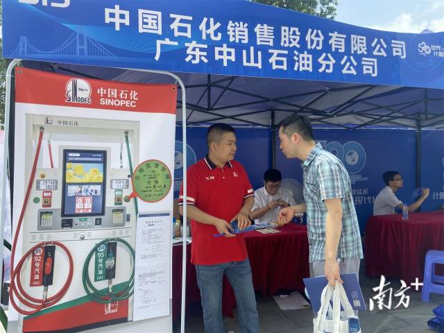 工作人员向市民介绍加油站相关知识。