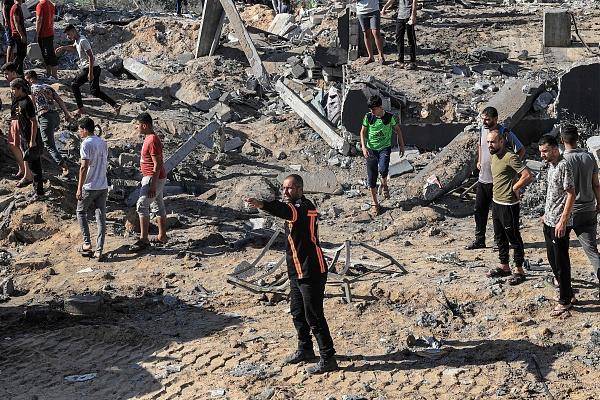 △10月13日，以色列空袭巴勒斯坦加沙地带拉法省后，民众在废墟中搜寻遇难者。