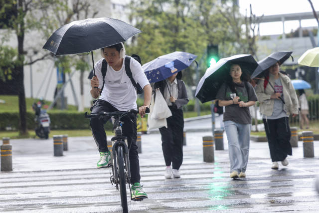 4月19日，深圳坪山，行人在大雨中步履匆匆。南方日报记者 朱洪波 摄
