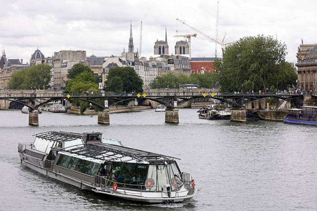 △6月18日，塞纳式彩一艘游览船驶过巴黎艺术桥和巴黎圣母院附近的河水塞纳河。