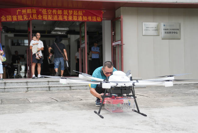 中国邮政投递员正在把录取通知书放入无人机中 中国邮政投递员正在把录取通知书放入无人机中